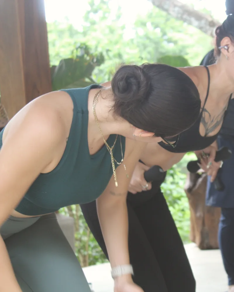 Una alumna con los brazos arriba bajo el árbol del deck
